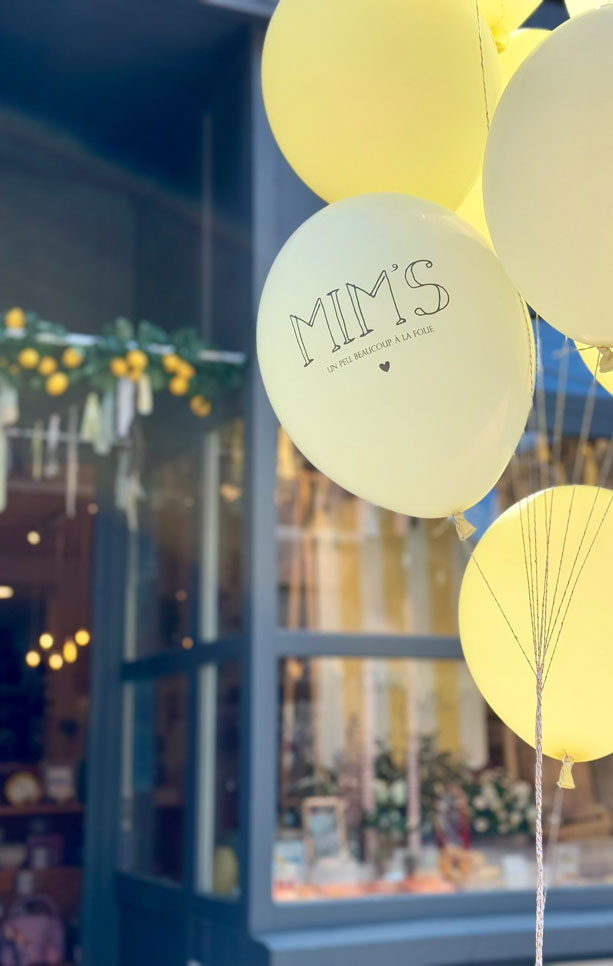 Ballons jaunes Mim's avec l'inscription « un peu, beaucoup, à la folie » devant la boutique à Leuze