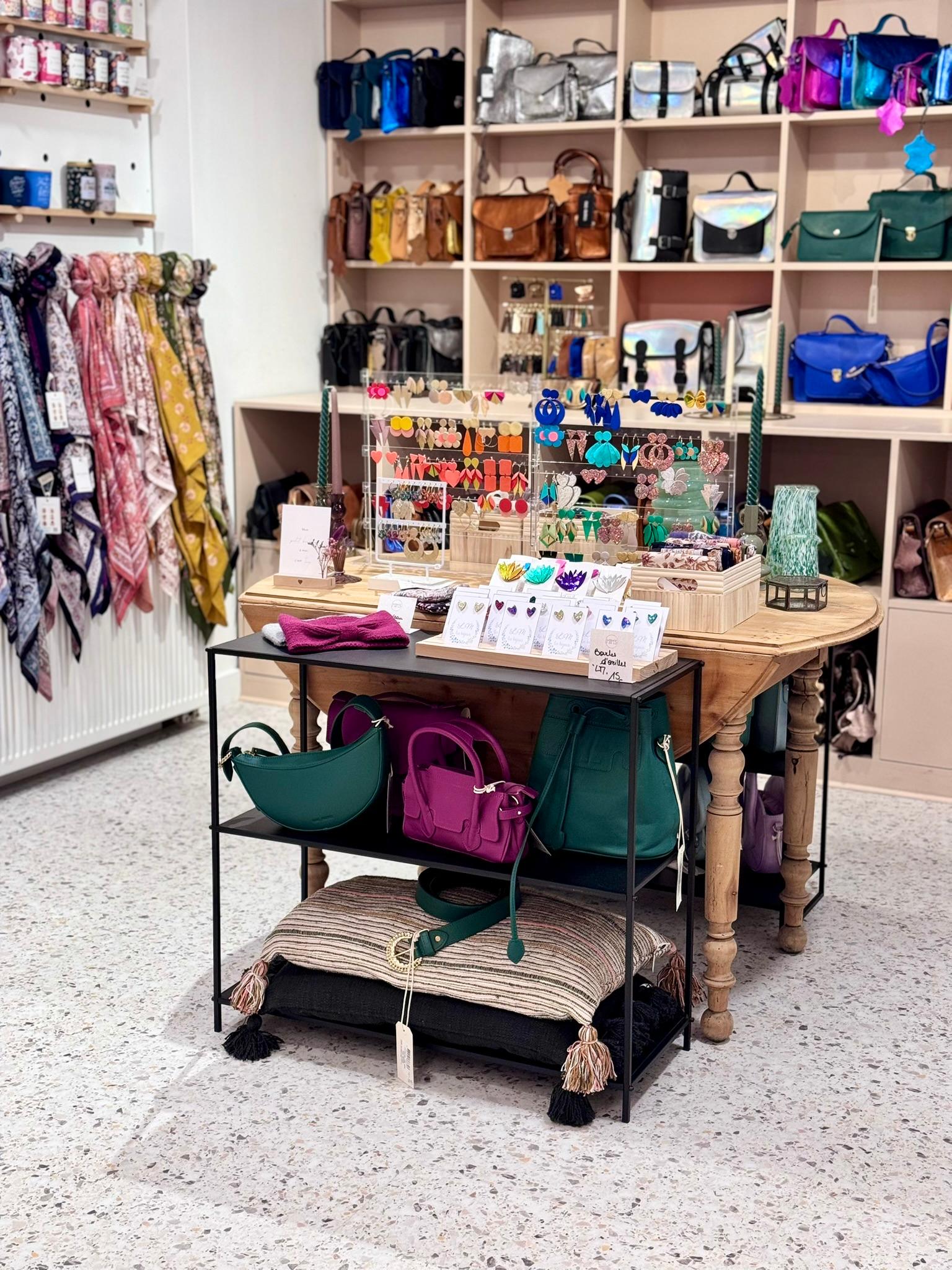 Présentation d'une table du magasin rempli de sacs, bijoux, boucles d'oreilles et autres accessoires