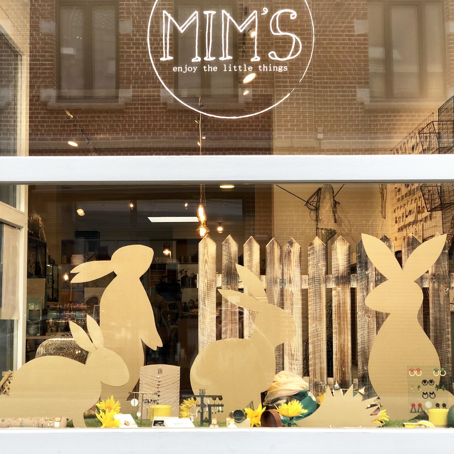 Vitrine de la boutique Mim's à Leuze-en-Hainaut décorée de lapins artisanaux en carton dans une ambiance printanière ou de Pâques, mettant en valeur des boucles d’oreilles et bijoux fantaisie