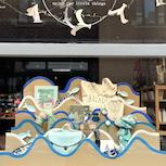 Vitrine Mim's avec décoration en vagues bleues et beiges et accessoires féminins